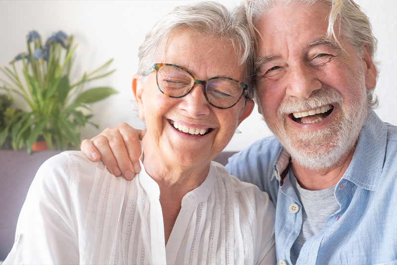 couple smiling after getting dentures