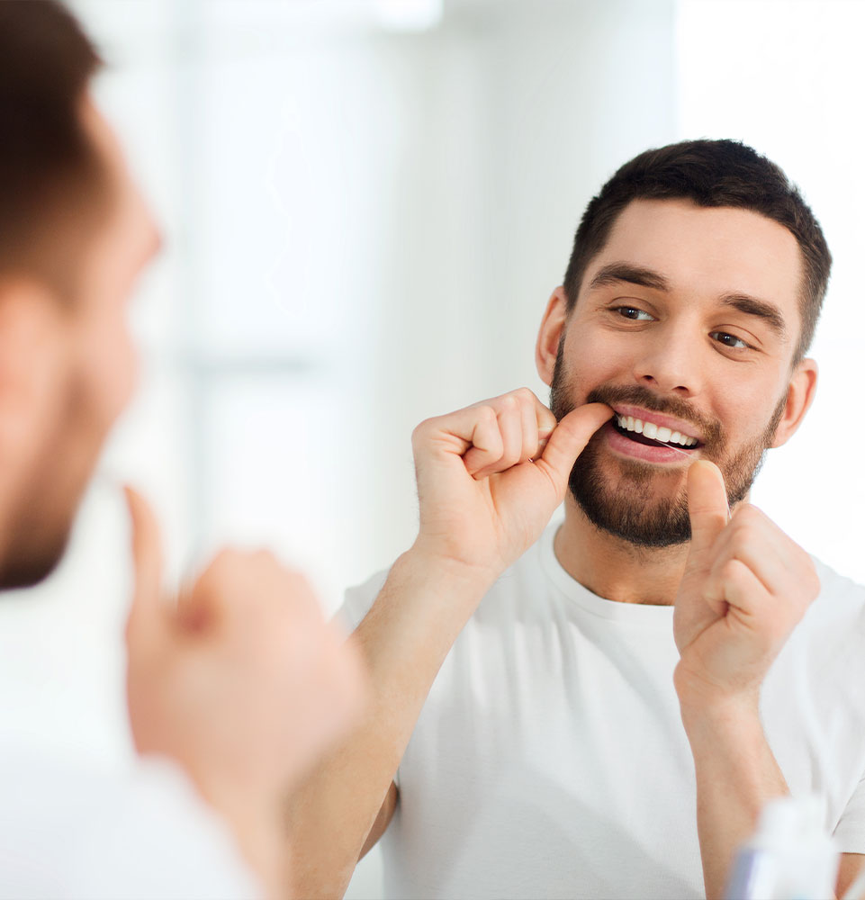 man flossing to prevent root canal