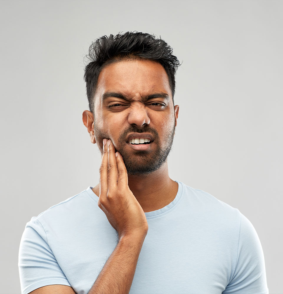 man holding mouth in pain due to tmj
